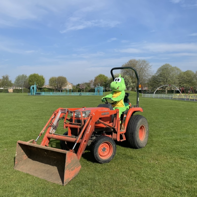 Parish tractor driven by a person in a dragon suit